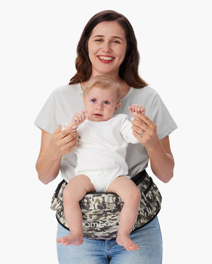 Mother holding a baby in a Momcozy hip seat carrier with camouflage pattern, providing comfort and support