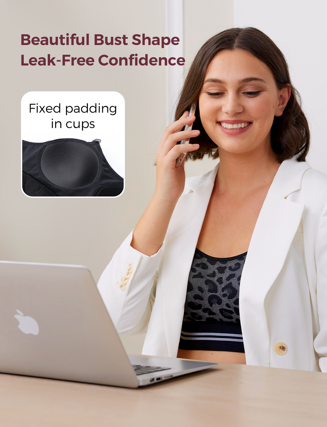 Woman wearing the HF022 4-in-1 hands-free seamless pumping bra, smiling at her phone with a laptop nearby, showcasing the bra's leak-free design.