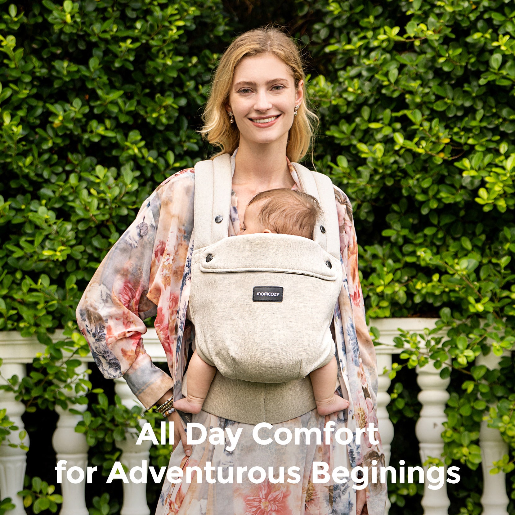 Momcozy PureHug beige baby carrier. Mother babywearing newborn for all-day comfort and adventurous beginnings.