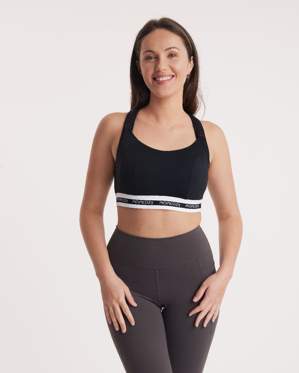 Model smiling in black Low Impact Nursing Sports Bra and high-waisted leggings for low-impact workouts.