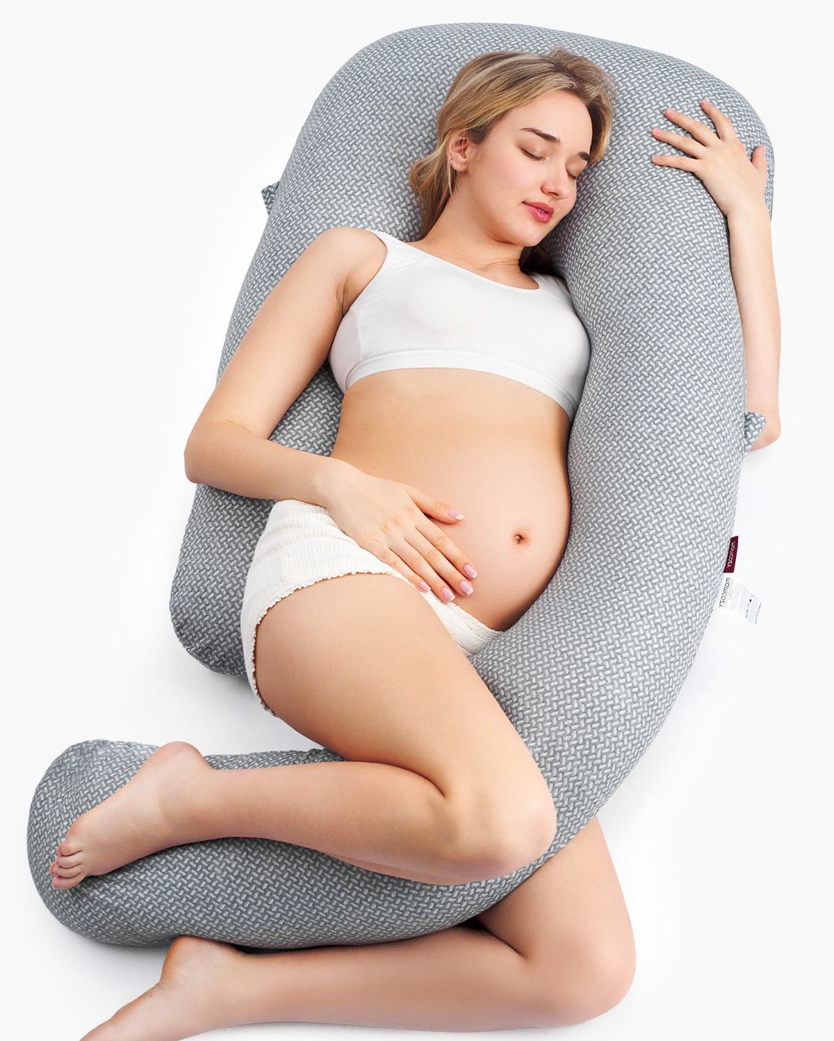 Momcozy Dreamlign pregnancy pillow supporting a pregnant woman, gray, promoting restful sleep and comfort.