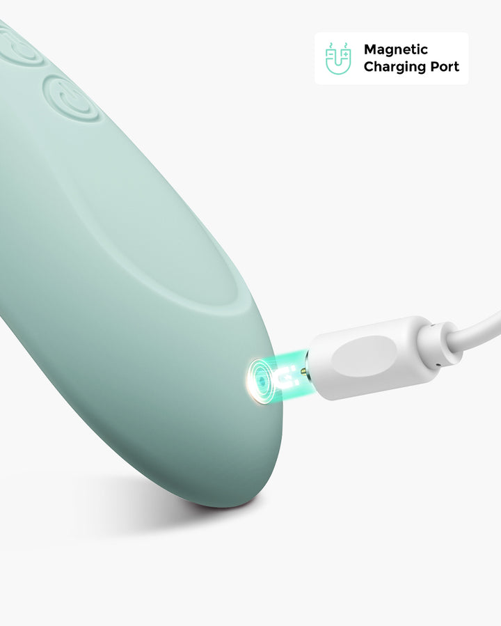 Close-up of 3 Mode Adjustable Kneading Lactation Massager in teal color being charged through a magnetic charging port, highlighting its easy charging capability
